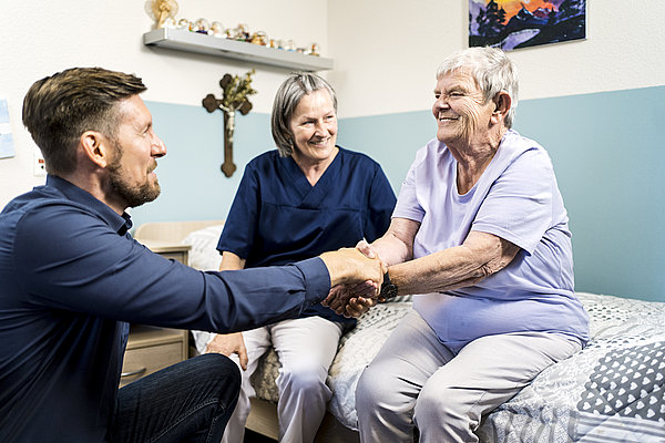 Begutachtungssituation: Pflegekraft, &auml;ltere Frau und Gutachter